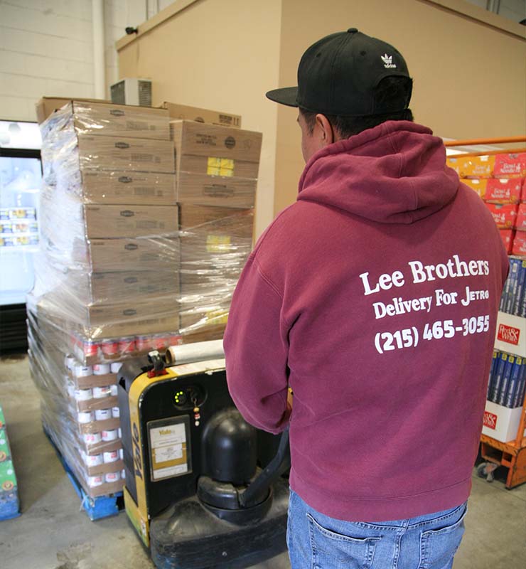 lee brothers worker using a machine to carry items for customer